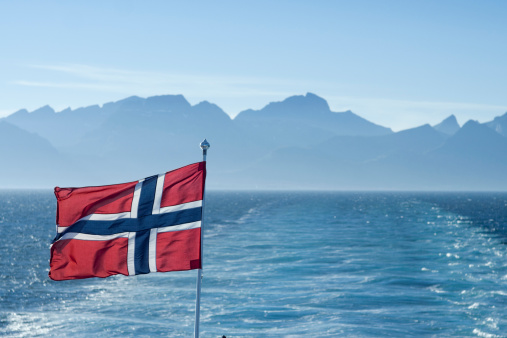 Norwegian Flag with Lofoten mountain range. 