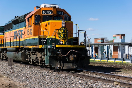 Fort Collins, Colorado, USA - May 13, 2014: A BNSF train in downtown Fort Collins with people in the background. Burlington Northern Santa Fe is a major railway operator and part of Warren Buffett's Berkshire Hathaway.