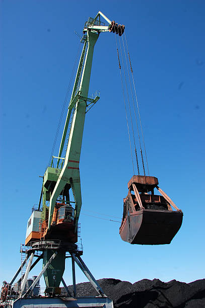 istock Crane loading coal to ship at Kolyma river port 506795008