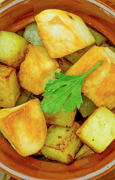 istock Fried potatoes, chunks of meat, pot, leaf parsley closeup 506796072