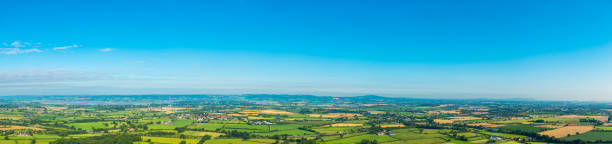 istock Big blue summer skies vibrant green patchwork landscape aerial panorama 506796483