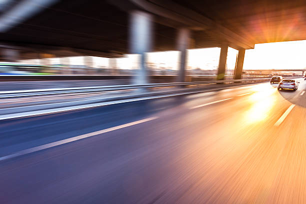 istock Car driving on freeway at sunset, motion blur 506798115