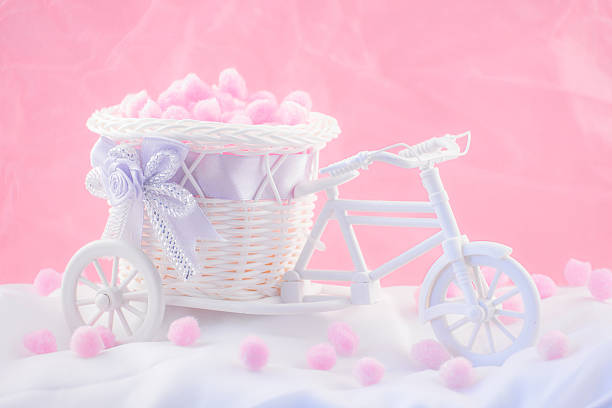 Tricycle souvenir on a pink background with fluffy donuts.