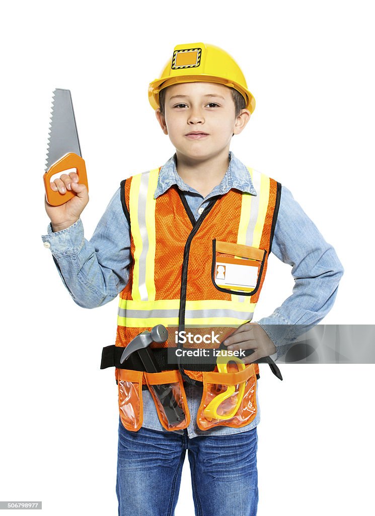 Junior Construction Worker Portrait of little boy dressed as contruction worker, holding a saw in hand and smiling at camera. Studio shot, isolated on white. Child Stock Photo