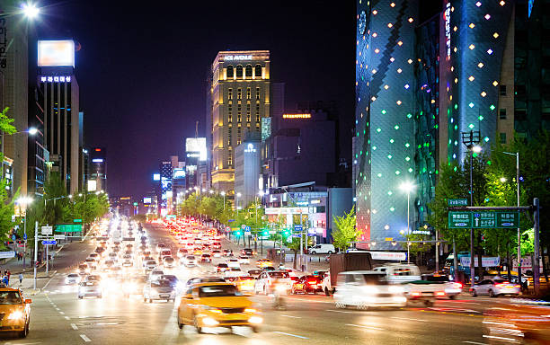 Seoul Dosan-Daero boulevard at night Seoul Dosan-Daero boulevard on a Springtime night with dense traffic, tall office buildings, hotels and shops lit by neon and street lights. kangnamgu stock pictures, royalty-free photos & images