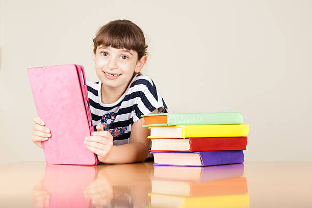 幸せな小さなスクールガールにタブレット - schoolgirl little girls crayon human face ストックフォトと画像