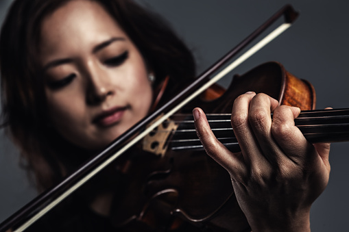beautiful professional musician holding violin isolated on black
