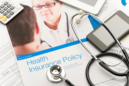 Health Insurance Policy brochure with paperwork. There is also a stethoscope, mobile phone and digital tablet in the image. The included image can also be found in my portfolio. Image # 22268159