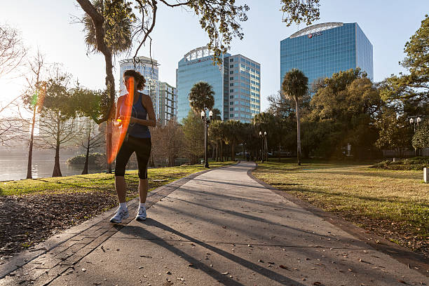 femme coureur jogging sur le lac eola park, à orlando - eola park photos et images de collection