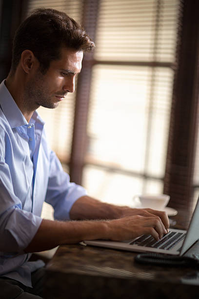 istock Handsome man typing on laptop 506815222