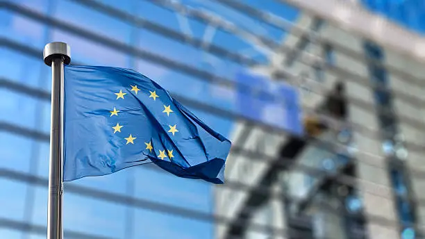 Photo of European Union flag against European Parliament