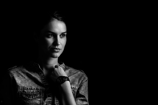 Close up of real teenage girl looking to camera against a plain background