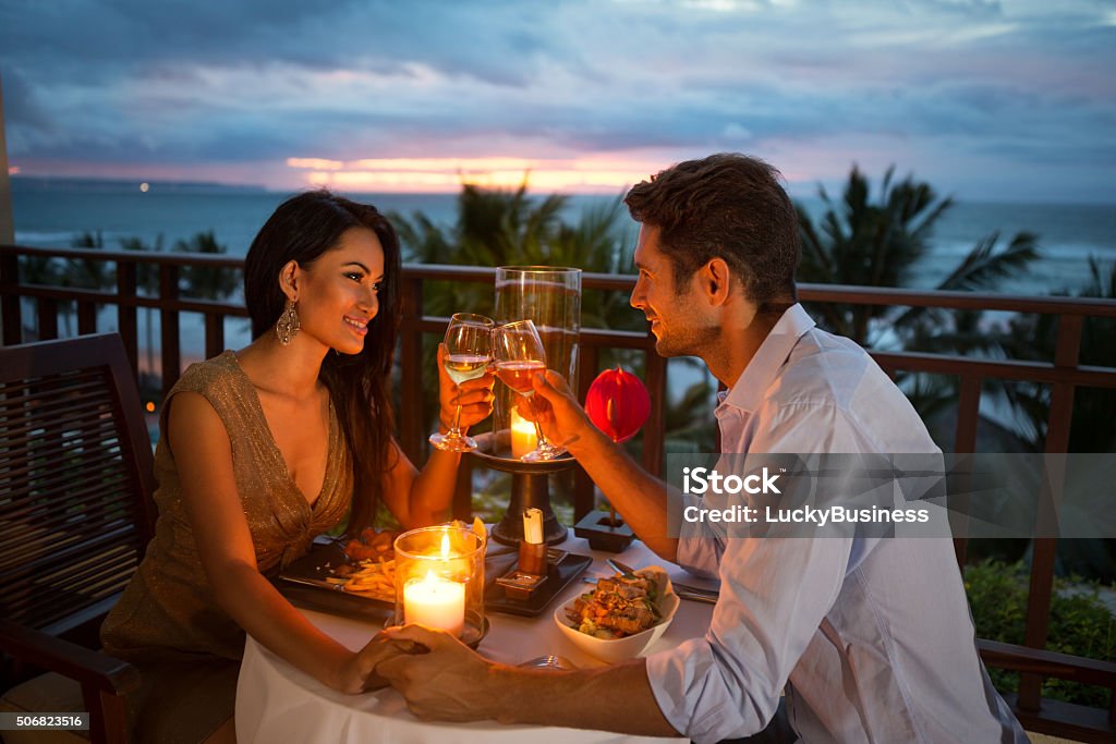 Coppia godendo una cena romantica un lume di candela - Foto stock royalty-free di Cena