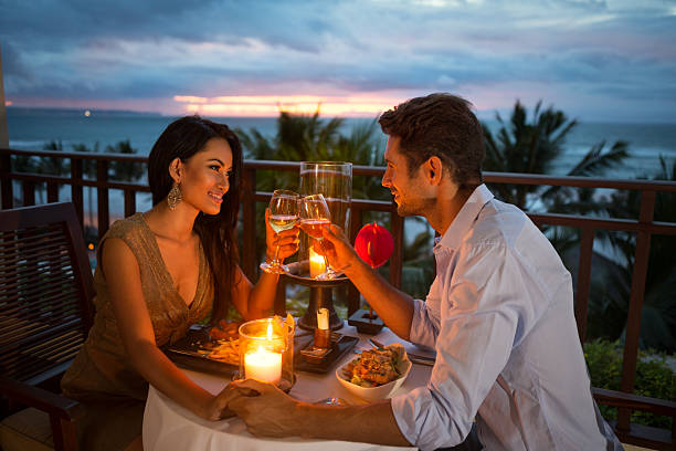 couple enjoying a romantic dinner by candlelight young couple enjoying a romantic dinner by candlelight, outdoor candle light dinner stock pictures, royalty-free photos & images