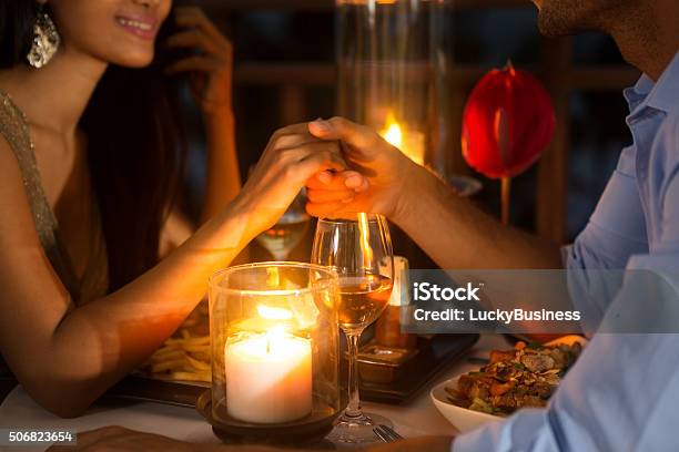 Romantisches Paar Hände Halten Zusammen Bei Kerzenlicht Stockfoto und mehr Bilder von Warmes Abendessen