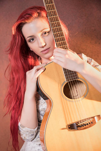 istock Red haired girl with a guitar 506825402