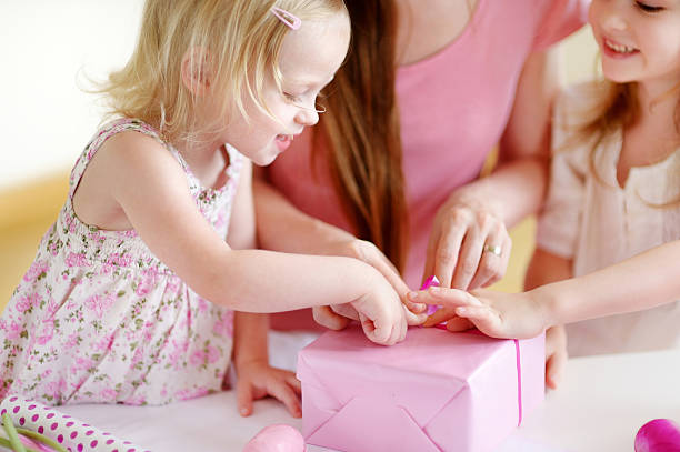 mère et deux filles het emballage cadeau - gift mothers day birthday giving photos et images de collection