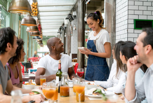 kellnerin nimmt bestellungen an die leute in einem restaurant - waitress stock-fotos und bilder