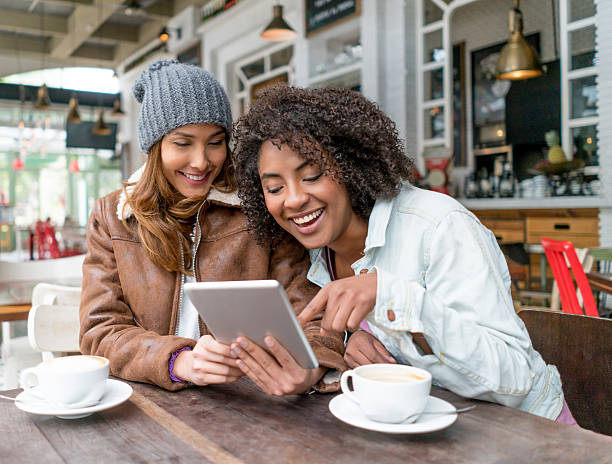 istock Women at a cafe social networking on a tablet 506828414