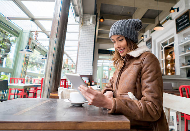 женщина в кафе с помощью планшетного компьютера - e reader digital tablet cafe reading стоковые фото и изображения