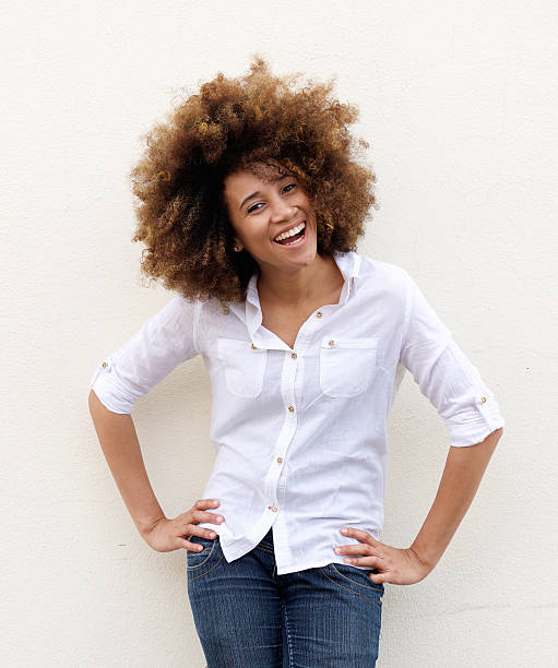 giovane donna ridendo con camicia bianca e capelli afro - laughing women shirt vertical foto e immagini stock