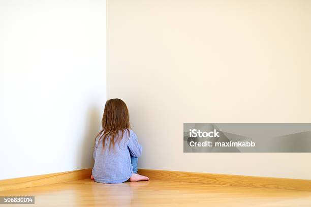 Sad Little Girl Sitting In A Corner Stock Photo - Download Image Now - Child, Punishment, Corner