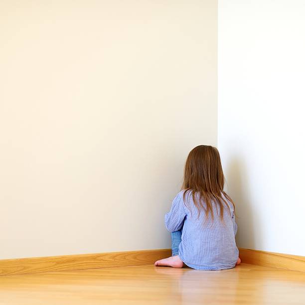 istock Sad little girl sitting in a corner 506830040