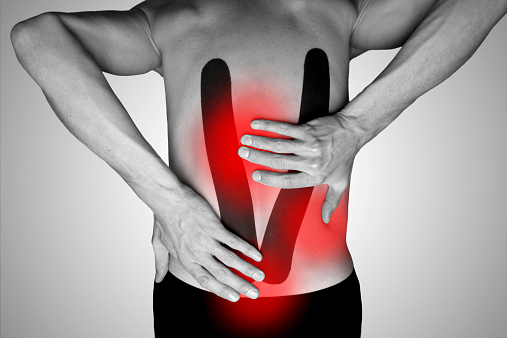 Man holding his lower back because of backache - the red color symbolizes the aching parts.