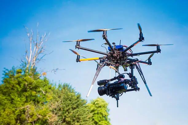 Professional camera mounted on a remote-control helicopter in flight.