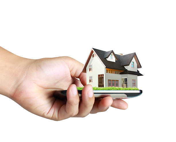 istock house on a mobile phone, in hand 506843679