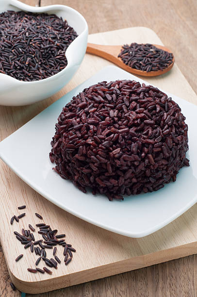 istock Black Rice cooked on white plate and  rice grains organic. 506845180