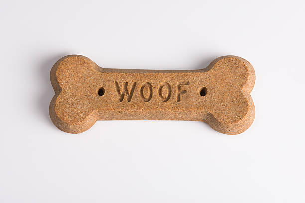 Dog Biscuit Dog biscuit with the word "woof". Shot on white seamless. dog biscuit photos stock pictures, royalty-free photos & images