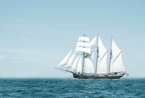 Three mast schooner under sails on the baltic sea. Cross processed.