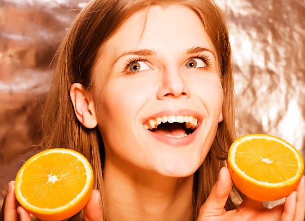 istock young pretty blond woman with half oranges close up isolated 506847154