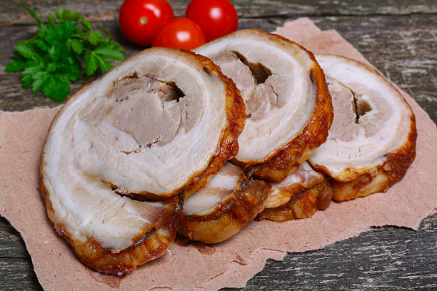 istock Sliced roasted roll pork loin with spices and fresh vegetables 506847172