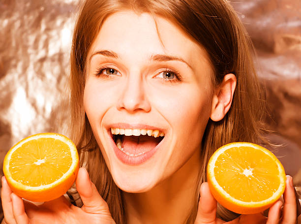 istock young pretty blond woman with half oranges close up isolated 506847194
