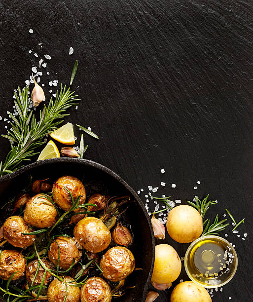 ローストポテトは、ストーン黒の背景 - lemon food preparation portion ストックフォトと画像