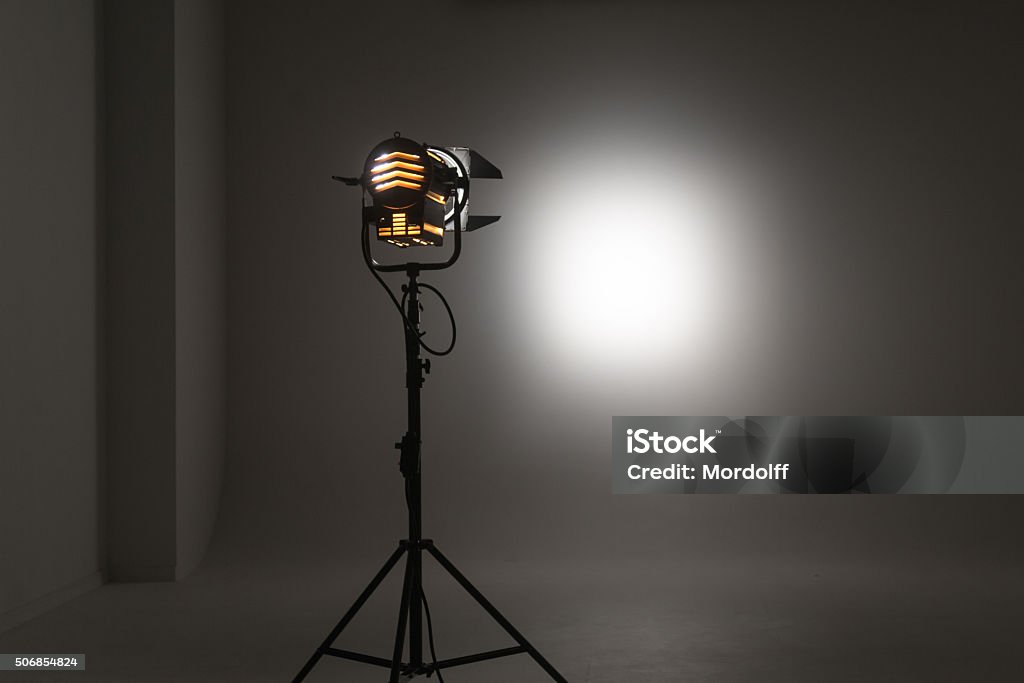 Studio Lighting Equipment Studio halogen continuous lighting with a Fresnel lens. The light beam of different intensity and shape. The beam of the halogen light directed to a white wall. Studio photography Art Stock Photo