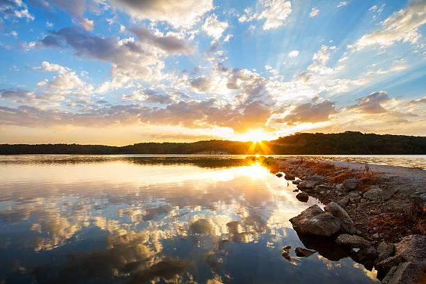 Rock Jetty Sunrise A dramatic sunrise along a rock jetty over a lake outside of Kansas City, Missouri. missouri stock pictures, royalty-free photos & images