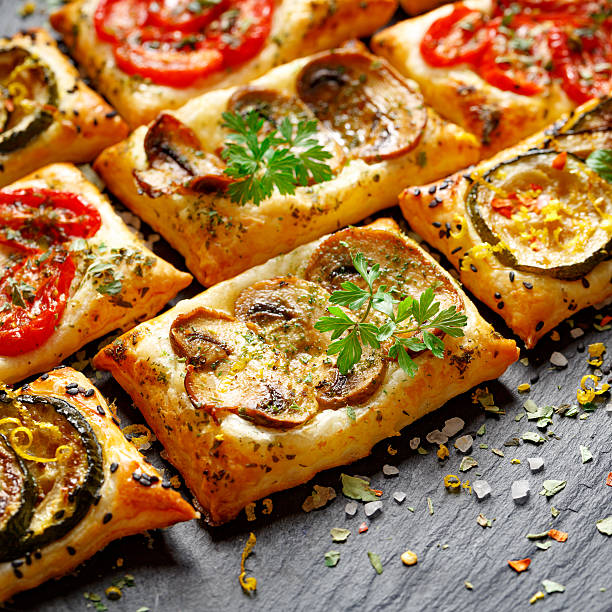 Tasty snacks puff pastry with tomatoes, mushrooms and zucchini