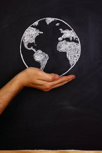 istock Holding earth front of black blackboard 506859816