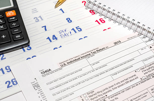istock tax form with calculator, pen, notepad above paper calendar 506859974