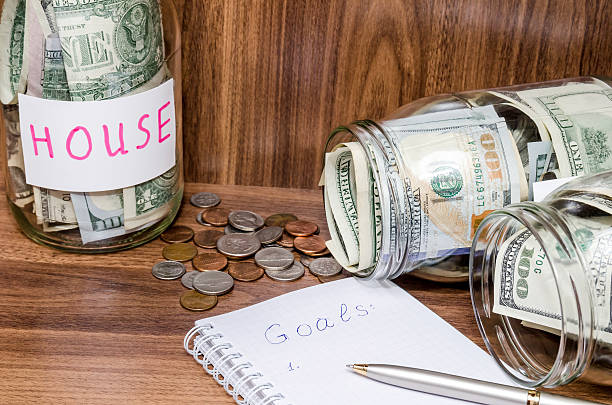 istock new years resolutions with dollar in glass jar, coins 506868310