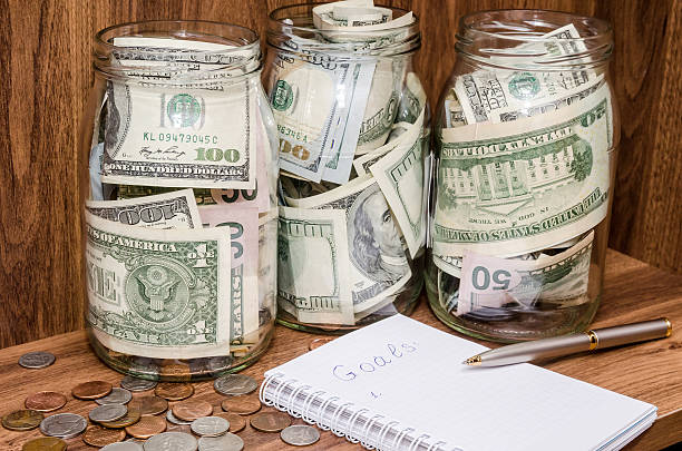 istock New years resolutions with dollar in glass jar, coins 506868370