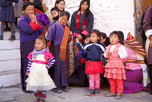 Trongsa, Bhutan - November 9, 2015: Bhutanese people in traditional clothes at the Trongsa Dzong, Trongsa, Bhutan. Trongsa Dzong is the largest dzong fortress in Bhutan. A temple was first established at the location in 1543 by the Drukpa Lama Ngagi Wangchuk. In 1647 his great-grandson Shabdrung Ngawang Namgyal constructed the first dzong to replace it.