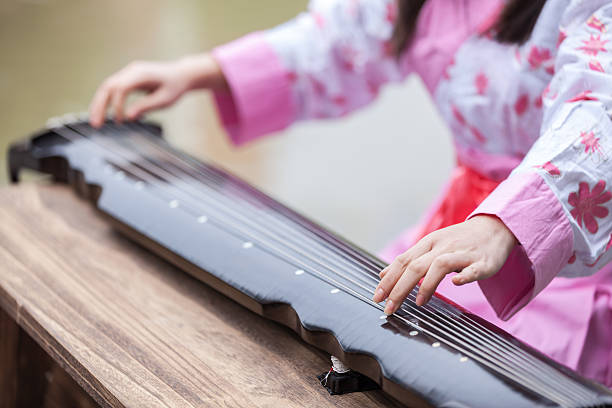 Asian young girl play on zither Asian young girl play on zither. psaltery stock pictures, royalty-free photos & images