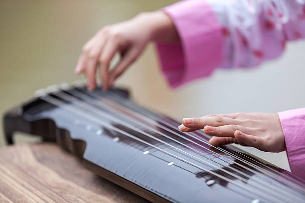 Asian young girl play on zither Asian young girl play on zither. psaltery stock pictures, royalty-free photos & images