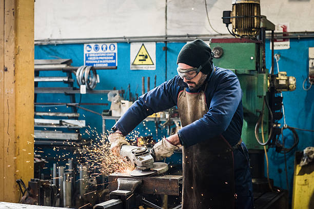 istock heavy industry manual worker with grinder 506869410