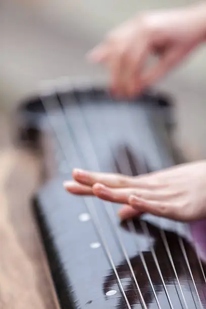 Asian young girl play on zither.