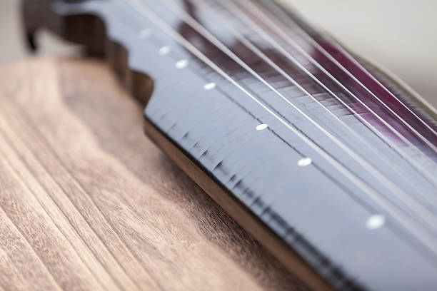 Close-up of Two Guitar Headstocks Against White Background
